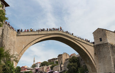 Low angle view of arch bridge and buildings against sky