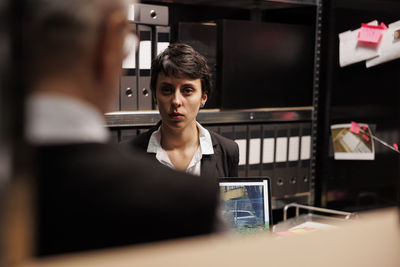 Portrait of young woman using mobile phone in office