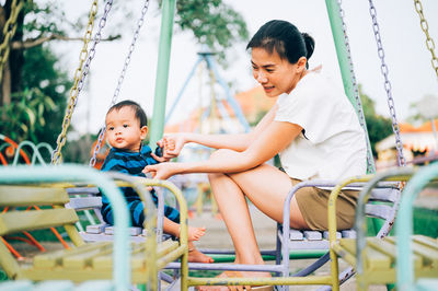 Boy sitting and woman in traditional clothing