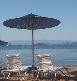 Deck chairs on beach against clear sky