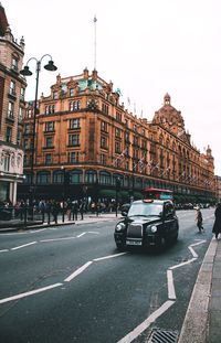 Cars on road in city against sky