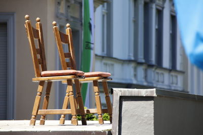 Close-up of chairs on table against building