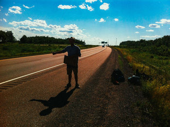 Rear view of man on road against sky