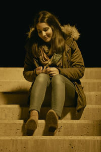 Full length of woman sitting outdoors