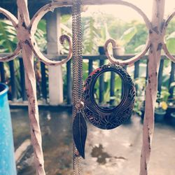 Close-up of rusty chain hanging on metal fence