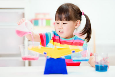Cute boy with toy toys on table