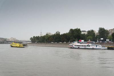 Boat sailing on river against clear sky