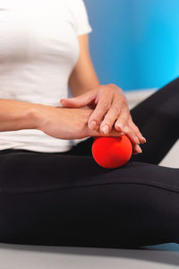 Close-up of a male massage therapist showing a client how to use and massage a ball. myofascial