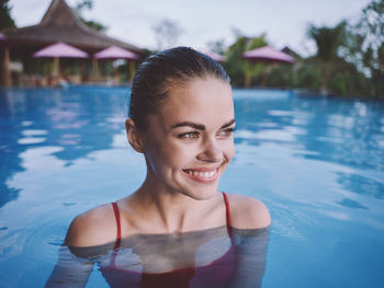 Portrait of smiling young woman in swimming pool