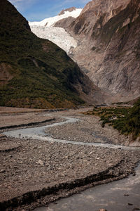 Scenic view of river amidst mountains against sky