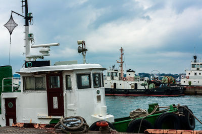 Ship moored at harbor against sky