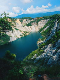 High angle view of lake amidst trees against sky