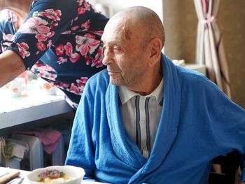 Portrait of senior man sitting on table