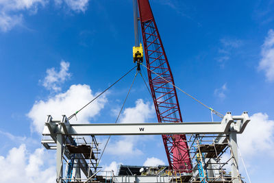 Low angle view of crane against blue sky
