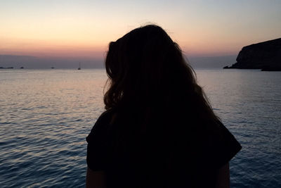 Woman looking at sunset over sea
