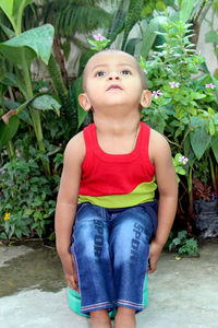 Girl looking up while standing in yard