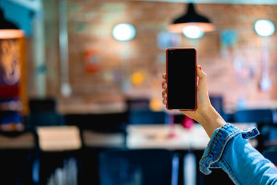 Midsection of person photographing illuminated smart phone