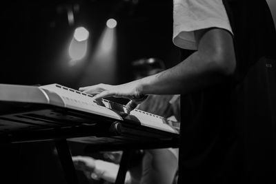 Midsection of musician playing piano during concert