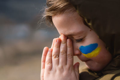 Ukrainian boy closed her eyes and praying to stop the war in ukraine.