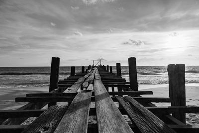 Wooden pier on sea against sky