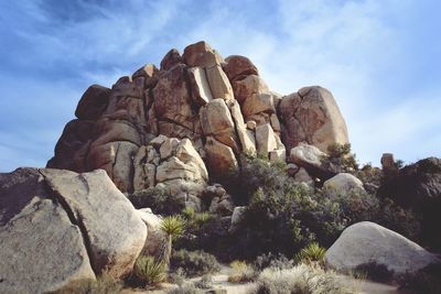 Low angle view of rock formation against cloudy sky