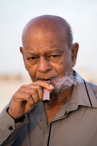 Portrait of senior man using vapour to smoke