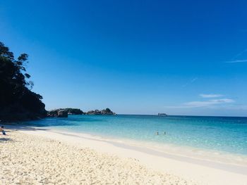 Scenic view of beach against blue sky