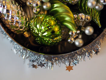 Directly above shot of shiny christmas ornaments on table