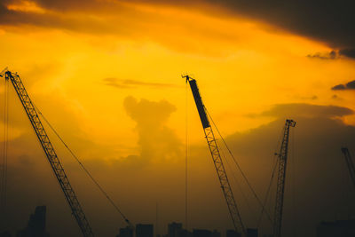 Low angle view of silhouette crane against sky during sunset