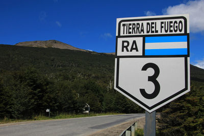 Road sign against blue sky