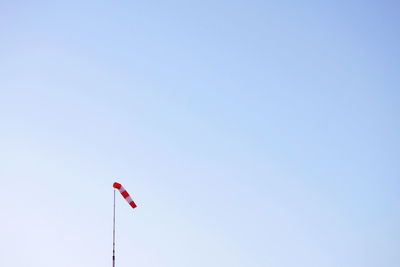 Low angle view of windsock against clear sky