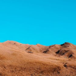 Scenic view of desert against clear blue sky