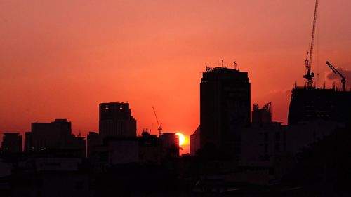Silhouette cityscape against sky during sunset