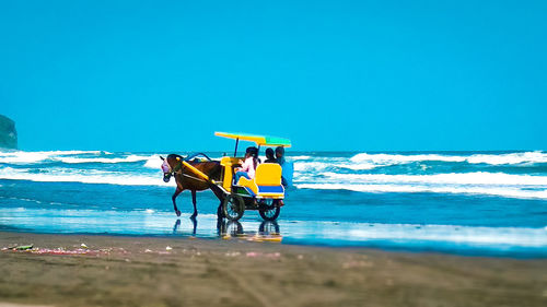 Lifeguard hut on beach against clear blue sky