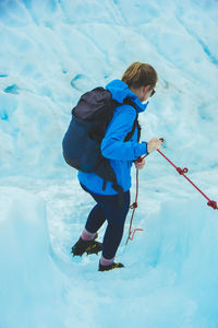 High angle view of young woman walking on glacier