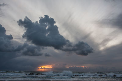 Scenic view of sea against storm clouds