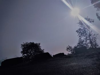 Silhouette trees on field against sky