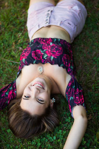 High angle view portrait of teenage girl lying on grass