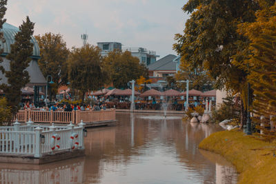 Swimming pool by river against buildings in city