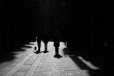 Rear view of people walking on footpath