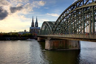 Arch bridge over river against sky