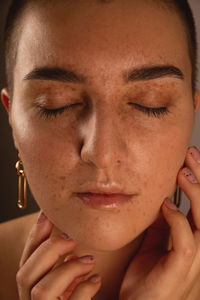 A swarthy girl with short hair and freckles with closed eyes. authentic close-up portrait