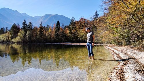 Full length of man standing by lake against sky