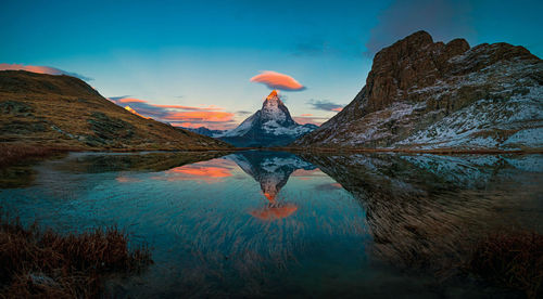 Scenic view of lake by mountain against sky