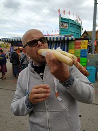 Portrait of man eating food in city