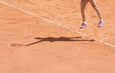 Low section of woman with shadow on floor