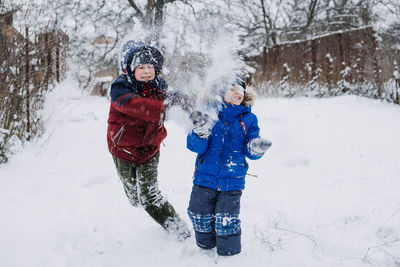 Outdoor winter activities for kids. kids playing in the suburbs, winter backyard gathering. boys 