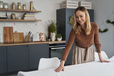 Smiling woman setting table for lunch