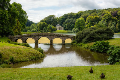 Arch bridge over river against sky