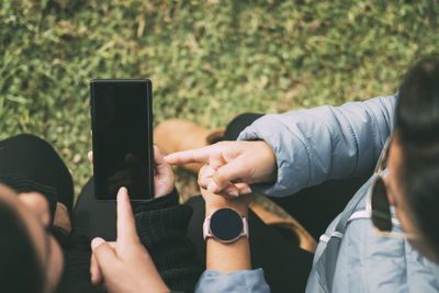 Cut out hands a woman with a smart watch pointing to a smartphone technology concept social networks